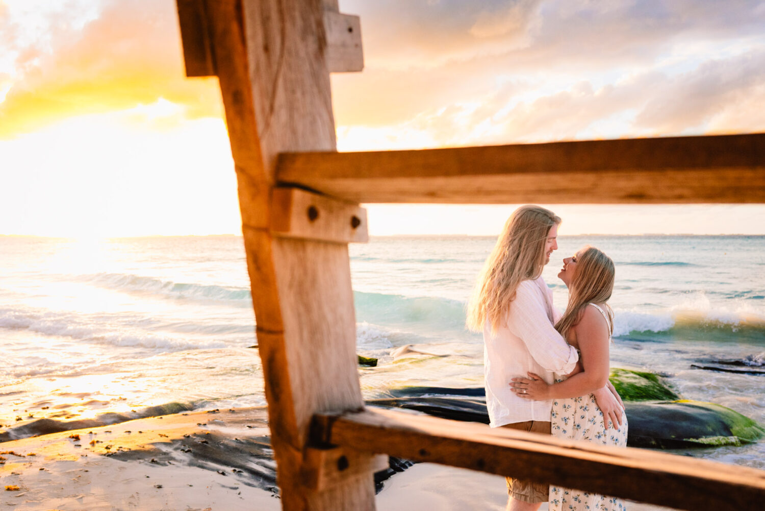 couple embracing during sunset photoshoot in Isla Mujeres